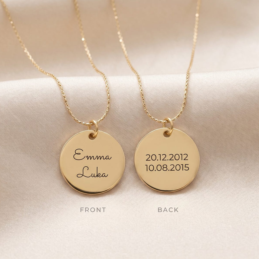 Two gold round pendant necklaces displayed on a soft cream fabric background, showing the front and back sides of the personalized disc pendants.